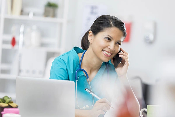 Happy nurse on the phone with a patient